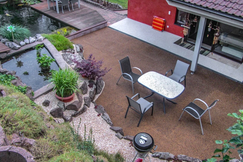 An idyllic oasis of well-being for the family between the hillside and the house. A spacious terrace made of WARCO slabs and a natural pond invite you to linger. The lushly overgrown embankment protection frames the family oasis.