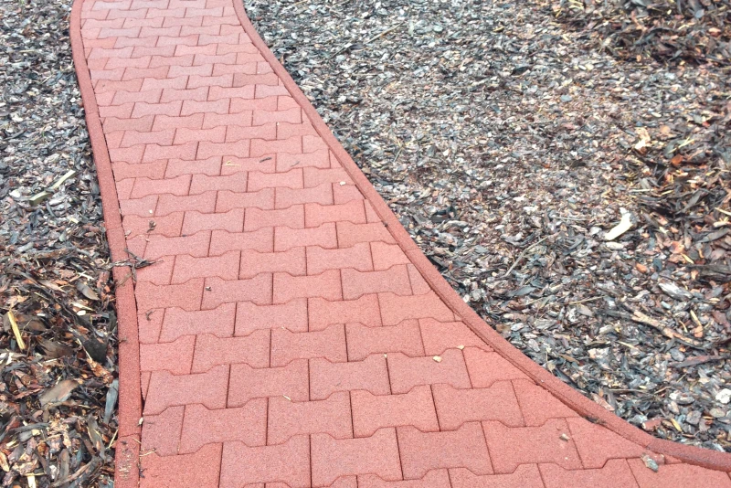 A red path with WARCO bone stones curves through a garden.