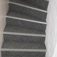 Grijze trap van binnen na de bekleding. Binnenkant ontworpen met WARCO trapbekleding.