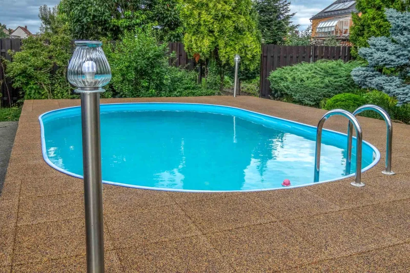 The natural earth tones of the water-permeable WARCO swimming pool tiles (Terra Cotta colour design) blend in perfectly with the garden landscape in which the pool is located.